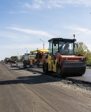 Asfalt kaplama yeni yol inşaat site üzerinde çalışan, ağır titreşim silindir. Onarma.