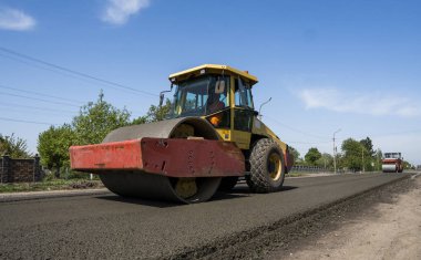 Asfalt kaplama yeni yol inşaat site üzerinde çalışan, ağır titreşim silindir. Onarma.