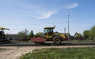 Asfalt kaplama yeni yol inşaat site üzerinde çalışan, ağır titreşim silindir. Onarma.