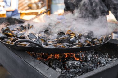 Taze ızgara tava, midye. Deniz açık havada barbekü. Piknik sağlıklı gıda, midye kabukları içinde. Çok geniş metalik pan pişirme midye kabukları