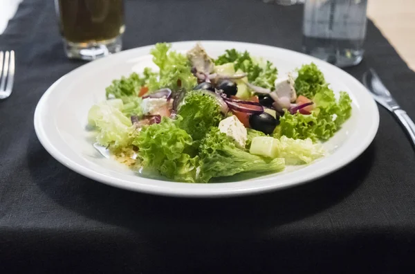 Ensalada César con filete de pollo y queso parmesano, cebolla, aceitunas, ensalada . —  Fotos de Stock