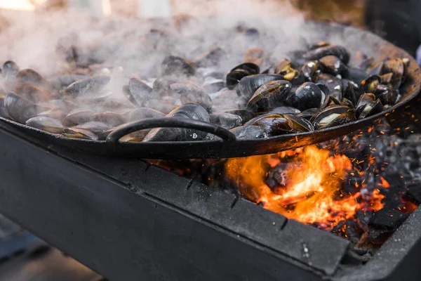 Fresh mussels at grill pan. Seafood barbecue outdoors. Picnic healthy food, mussels in shells. Plenty of mussel shells cooking at large metallic pan. — Stock Photo, Image
