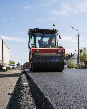 Asfalt kaplama yeni yol inşaat site üzerinde çalışan, ağır titreşim silindir. Onarma.