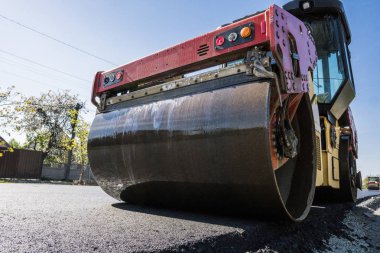 Asfalt kaplama yeni yol inşaat site üzerinde çalışan, ağır titreşim silindir. Onarma.