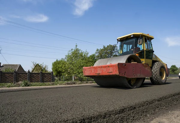 Asfalt kaplama yeni yol inşaat site üzerinde çalışan, ağır titreşim silindir. Onarma.