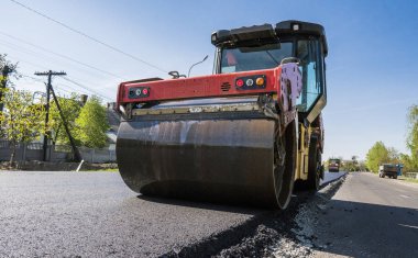 Asfalt kaplama yeni yol inşaat site üzerinde çalışan, ağır titreşim silindir. Onarma.