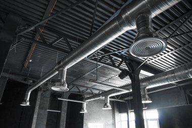 Büyük binaların tavanındaki havalandırma sistemi. Yeni binanın tavanından sarkan gümüş yalıtım malzemelerindeki havalandırma boruları..