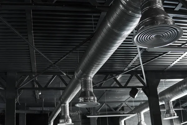 Büyük binaların tavanındaki havalandırma sistemi. Yeni binanın tavanından sarkan gümüş yalıtım malzemelerindeki havalandırma boruları..