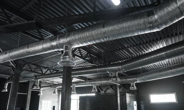 Sistema de ventilação no teto de grandes edifícios. Tubos de ventilação em material de isolamento de prata pendurado no teto dentro do novo edifício . — Fotografia de Stock