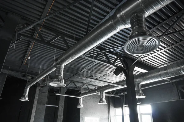 Büyük binaların tavanındaki havalandırma sistemi. Yeni binanın tavanından sarkan gümüş yalıtım malzemelerindeki havalandırma boruları..