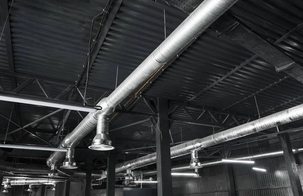 Büyük binaların tavanındaki havalandırma sistemi. Yeni binanın tavanından sarkan gümüş yalıtım malzemelerindeki havalandırma boruları..