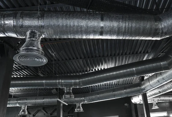 Büyük binaların tavanındaki havalandırma sistemi. Yeni binanın tavanından sarkan gümüş yalıtım malzemelerindeki havalandırma boruları..