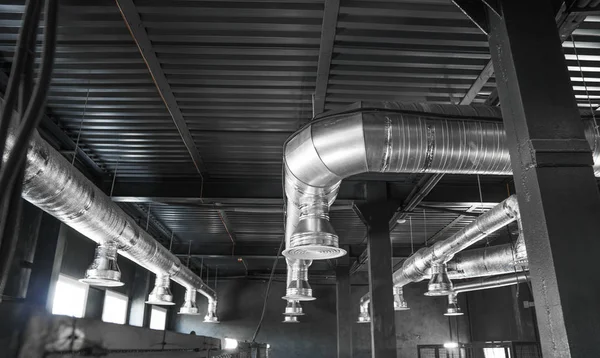 Ventilation system on the ceiling of large buildings. Ventilation pipes in silver insulation material hanging from the ceiling inside new building. — Stock Photo, Image
