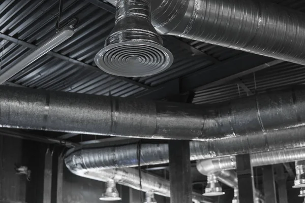 Büyük binaların tavanındaki havalandırma sistemi. Yeni binanın tavanından sarkan gümüş yalıtım malzemelerindeki havalandırma boruları..