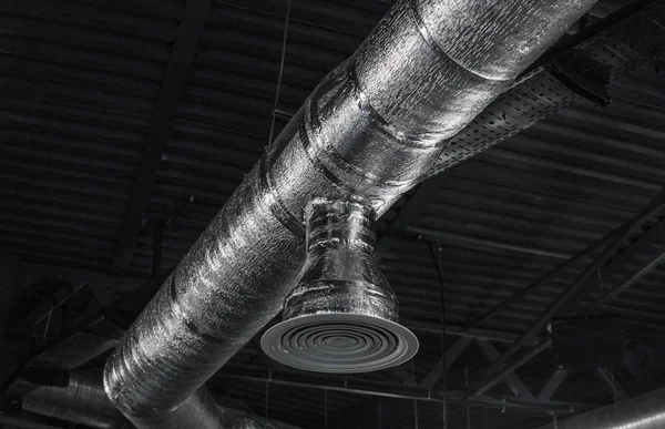 Sistema de ventilação no teto de grandes edifícios. Tubos de ventilação em material de isolamento de prata pendurado no teto dentro do novo edifício . — Fotografia de Stock