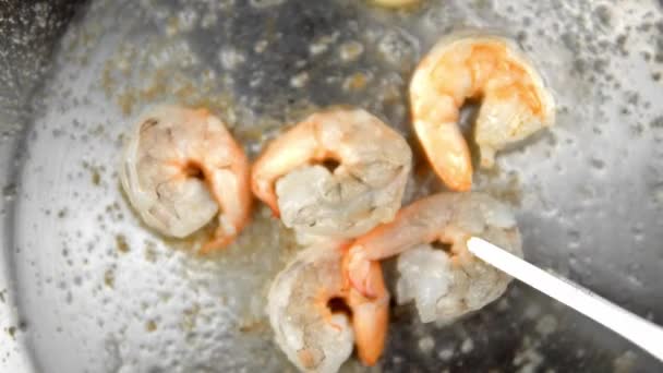 Close up on a shrimps fry on a frying pan with a garlic and rosemary. The chef turns the shrimp to the other side. — Stock Video