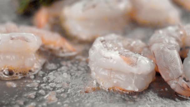 Närbild på matlagning räkor på en stekpanna med smör och strö över salt. — Stockvideo