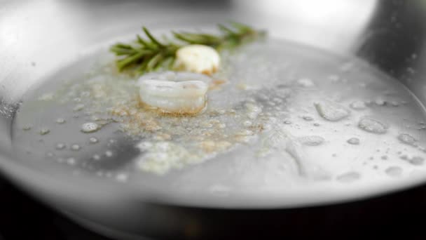 El primer plano a la cocción de los langostinos en la cacerola con la mantequilla con el ajo y el romero . — Vídeo de stock