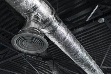 Büyük binaların tavanındaki havalandırma sistemi. Yeni binanın tavanından sarkan gümüş yalıtım malzemelerindeki havalandırma boruları..