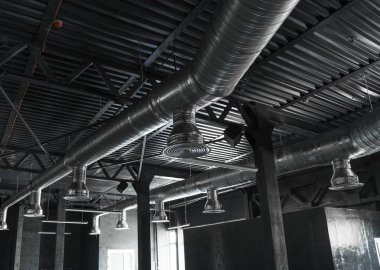 Büyük binaların tavanındaki havalandırma sistemi. Yeni binanın tavanından sarkan gümüş yalıtım malzemelerindeki havalandırma boruları..