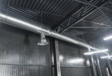 Büyük binaların tavanındaki havalandırma sistemi. Yeni binanın tavanından sarkan gümüş yalıtım malzemelerindeki havalandırma boruları..