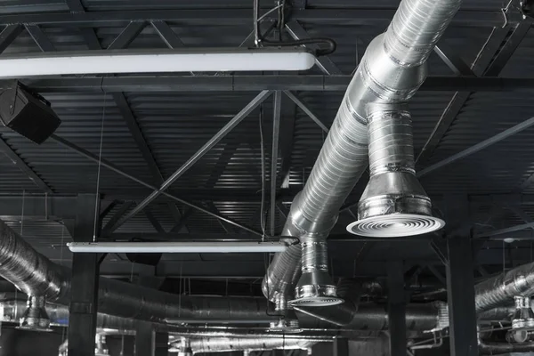 Sistema de ventilação no teto de grandes edifícios. Tubos de ventilação em material de isolamento de prata pendurado no teto dentro do novo edifício . — Fotografia de Stock