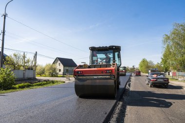 Asfalt kaplama yeni yol inşaat site üzerinde çalışan, ağır titreşim silindir. Onarma.