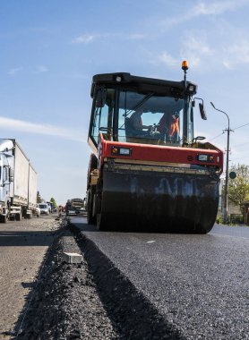 Asfalt kaplama yeni yol inşaat site üzerinde çalışan, ağır titreşim silindir. Onarma.