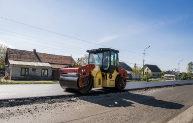 Asfalt kaplama yeni yol inşaat site üzerinde çalışan, ağır titreşim silindir. Onarma.