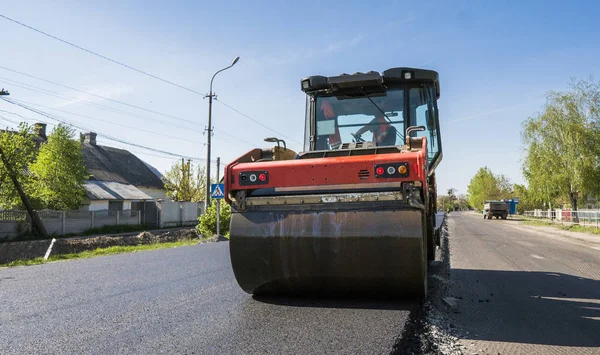 Asfalt kaplama yeni yol inşaat site üzerinde çalışan, ağır titreşim silindir. Onarma.