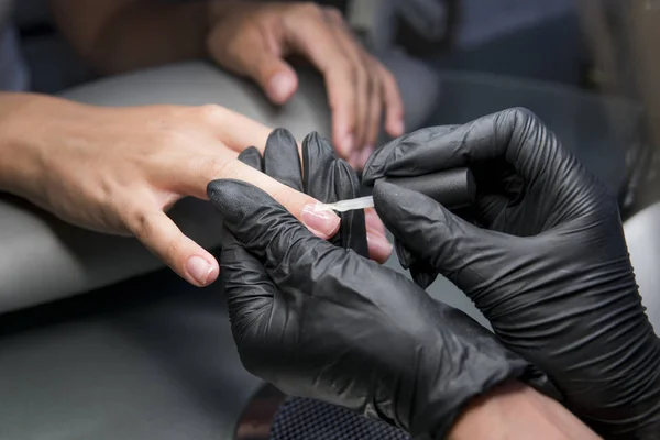 Vrouw met een nail manicure in een schoonheidssalon met een close-up beeld van een vernis toe te passen met een applicator schoonheidsspecialiste. — Stockfoto