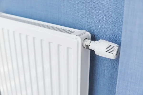 Vit radiator i en lägenhet med en blå väggar. — Stockfoto