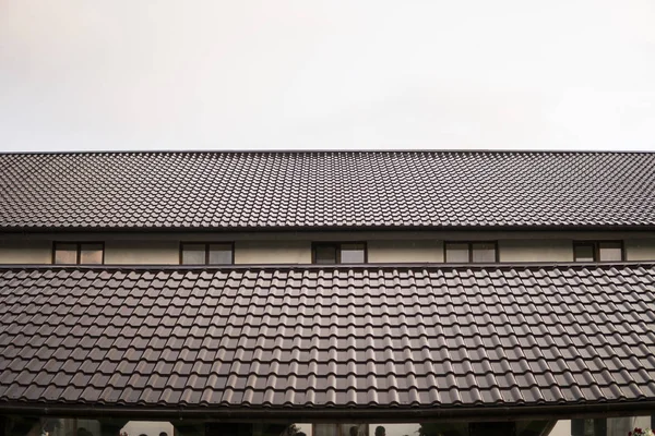 Modern çatı kiremit etkisi ile Pvc kaplı kahverengi metal çatı sayfaları bulutlu gökyüzü karşı kaplı..