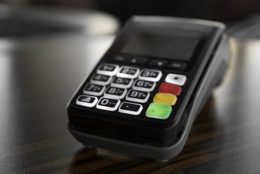 Karanlık bir tablo üzerinde siyah Pos terminal.