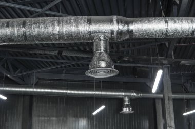 Büyük binaların tavanındaki havalandırma sistemi. Yeni binanın tavanından sarkan gümüş yalıtım malzemelerindeki havalandırma boruları..