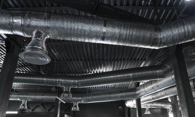 Büyük binaların tavanındaki havalandırma sistemi. Yeni binanın tavanından sarkan gümüş yalıtım malzemelerindeki havalandırma boruları..