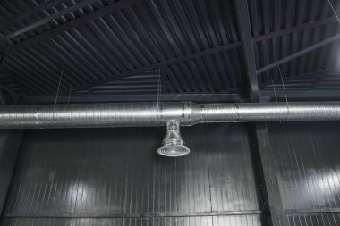 Büyük binaların tavanındaki havalandırma sistemi. Yeni binanın tavanından sarkan gümüş yalıtım malzemelerindeki havalandırma boruları..