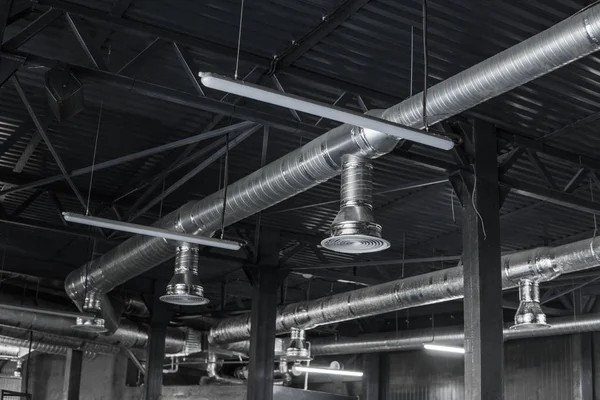 Sistema de ventilação no teto de grandes edifícios. Tubos de ventilação em material de isolamento de prata pendurado no teto dentro do novo edifício . — Fotografia de Stock