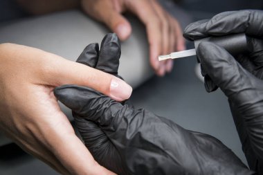 Güzellik Salonu bir aplikatör ile vernik uygulama bir güzellik closeup manzaralı manikür çivi olan kadın.