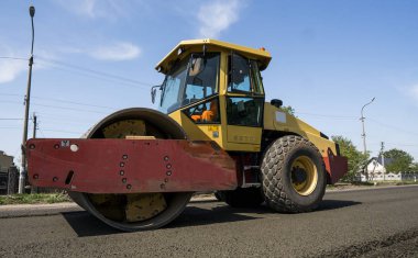 Asfalt kaplama yeni yol inşaat site üzerinde çalışan, ağır titreşim silindir. Onarma.