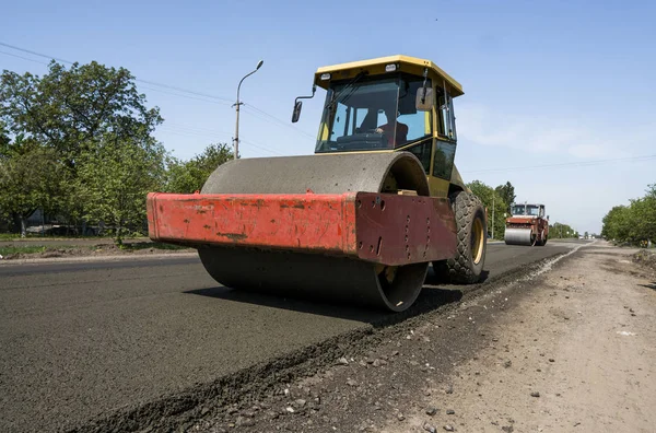 Heavy Vibration roller at asphalt pavement working on the new road construction site. Repairing.