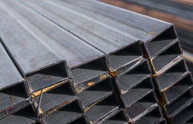 Yassı haddelenmiş boru metal profil metal ürünlerin depodaki paketlerine kare. İnşaat için metaller profilleri yıpranmış. Metal korozyon.