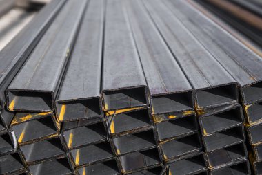 Yassı haddelenmiş boru metal profil metal ürünlerin depodaki paketlerine kare. İnşaat için metaller profilleri yıpranmış. Metal korozyon.