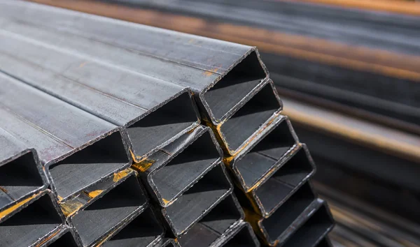 Yassı haddelenmiş boru metal profil metal ürünlerin depodaki paketlerine kare. İnşaat için metaller profilleri yıpranmış. Metal korozyon.