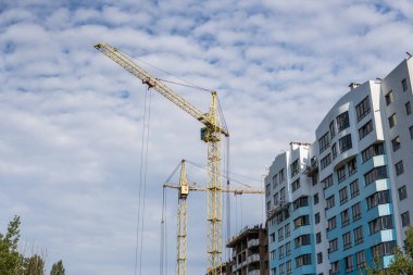 Vinç ve bina inşaat mavi bulutlu gökyüzü altında.
