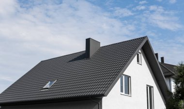 Modern roof covered with tile effect PVC coated brown metal roof sheets. clipart