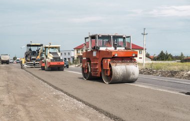 Turuncu ağır titreşim silindir kompaktör asfalt kaplama, yol onarmak için çalışır. Yeni yol inşaat alanı üzerinde çalışıyor. Onarma.
