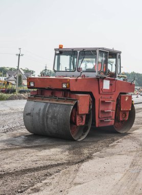 Turuncu ağır titreşim silindir kompaktör asfalt kaplama, yol onarmak için çalışır. Yeni yol inşaat alanı üzerinde çalışıyor. Onarma.