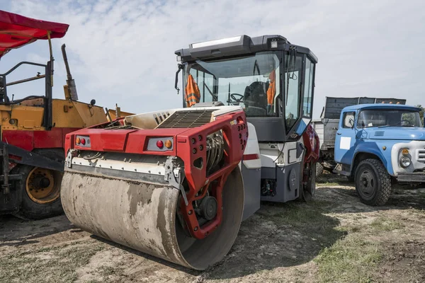 Red Heavy Vibration roller at asphalt pavement works. Road repairing. Road construction and repairing asphalt pavement works with a blue sky. — Stock Photo, Image