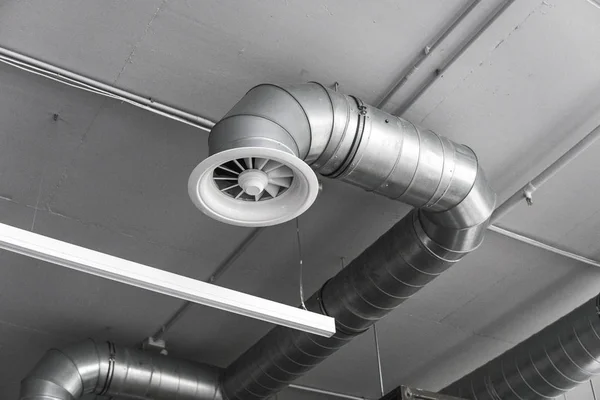 Sistema de ventilación en el techo de grandes edificios. Tubos de ventilación en material de aislamiento de plata colgando del techo dentro de un edificio nuevo . — Foto de Stock